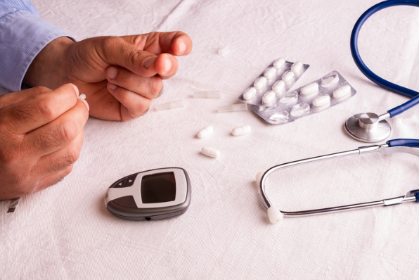 Manos recortadas haciendo una prueba de azúcar en la sangre